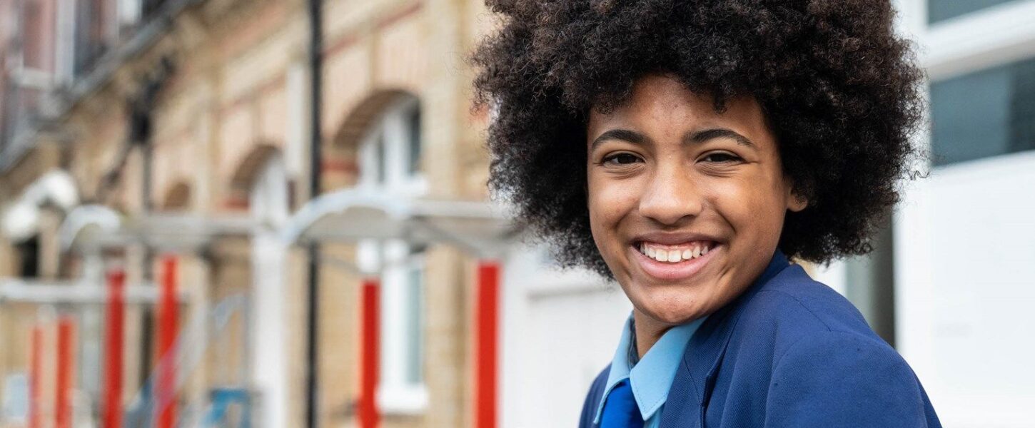 Teenage girl wearing a school uniform looking happy