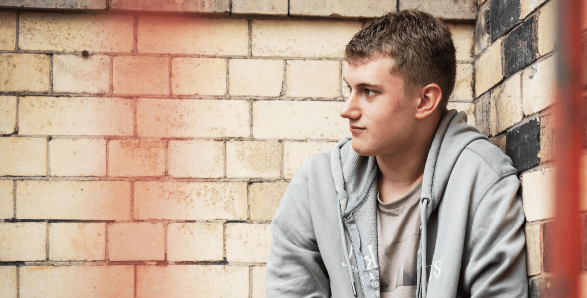 Teenage boy in front of a wall, looking to the right