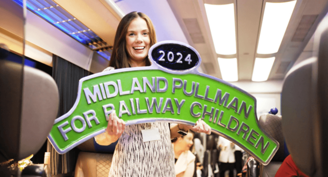 Woman holding the Midland Pullman for Railway Children sign.