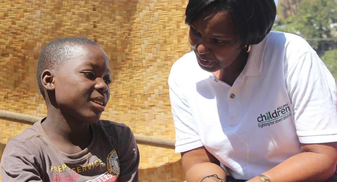 Railway children africa worker speaking to child